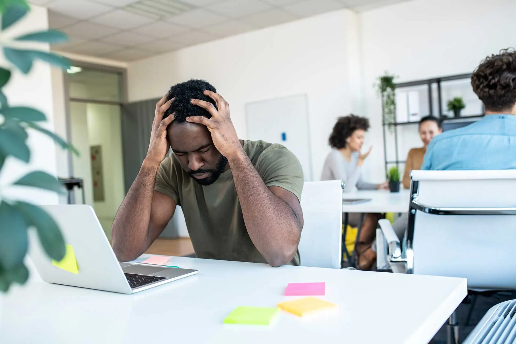 3 Signs You Need Professional Mental Health Treatment a man struggles with the symptoms of an undiagnosed mental health disorder at work