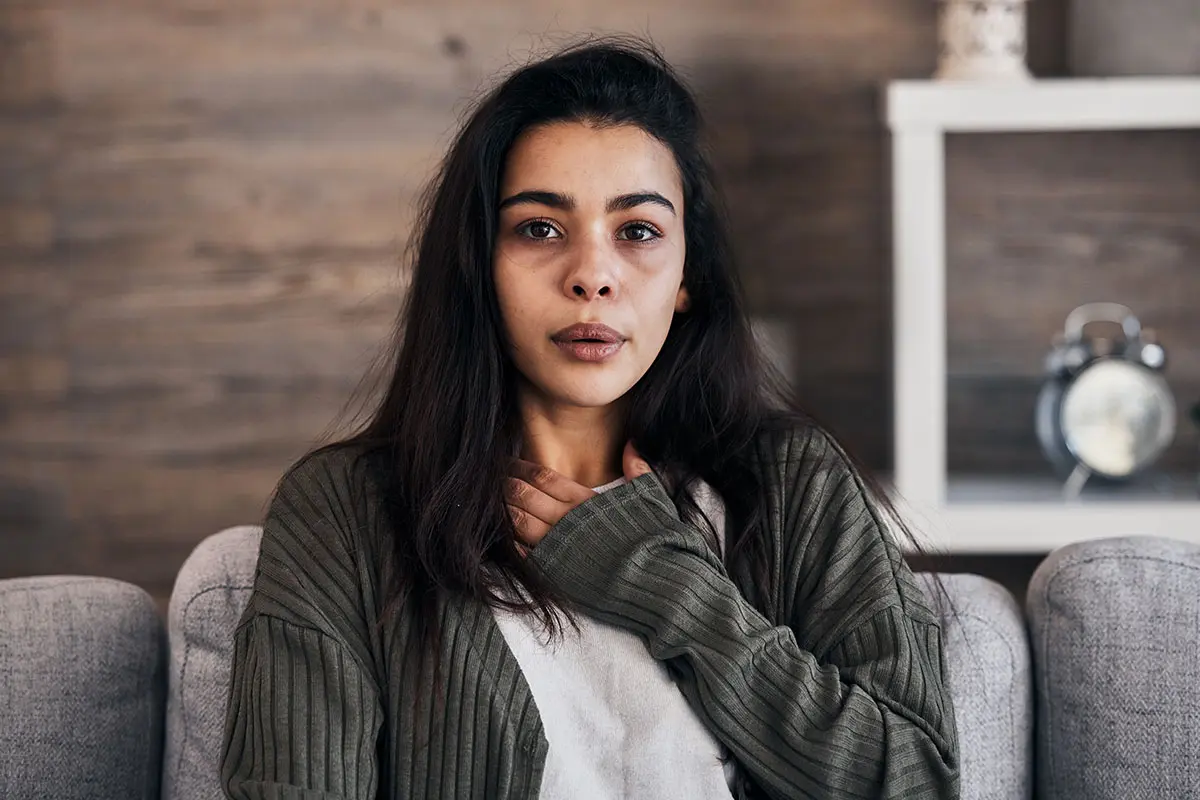 4 Causes of Severe Anxiety a person puts their hand on their chest as they wonder what causes severe anxiety