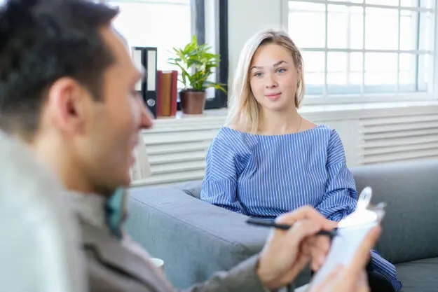 Finding Psychiatric Care in Central Florida a person sits on a couch and talks to a psychiatrist to show psychiatric care florida
