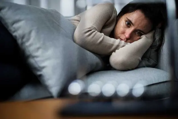 What-Does-it-Mean-to-Have-a-Severe-Mental-Illness– a woman struggles to get out of bed due to severe mental illness