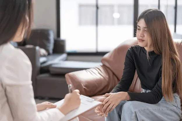 Therapist explaining the differences between psychosis and schizophrenia to a young adult, highlighting the importance of accurate diagnosis.