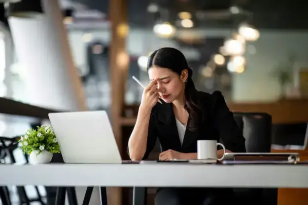 burnout-recovery-tips professional experiencing exhaustion while learning how to recover from burnout and manage stress.