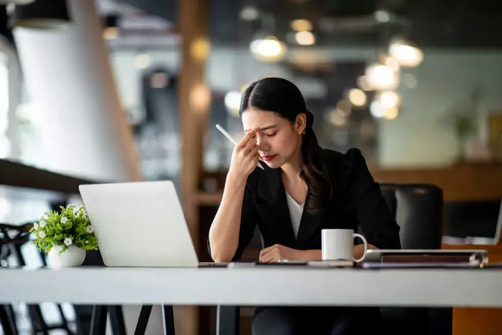 burnout-recovery-tips professional experiencing exhaustion while learning how to recover from burnout and manage stress.