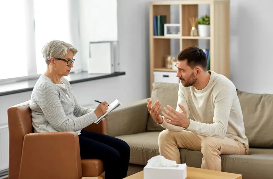 Therapist providing dual diagnosis treatment for PTSD and addiction, addressing both conditions together.
