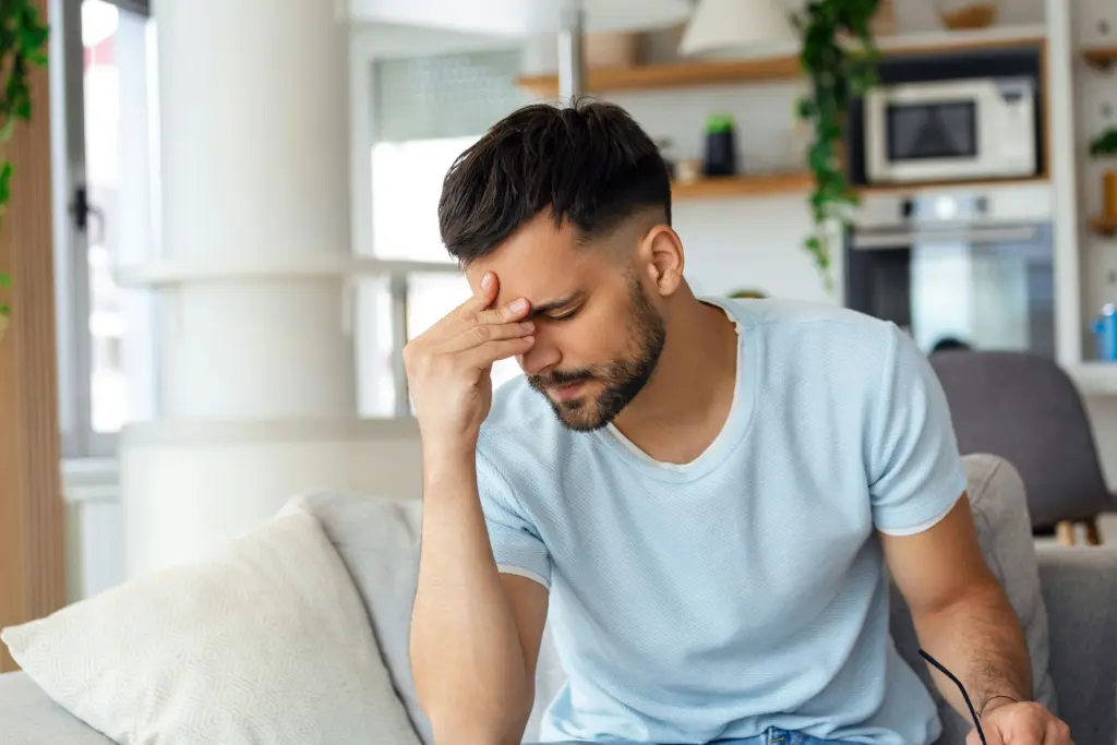 man sitting with head down and breathing deeply to prevent fainting during a panic attack