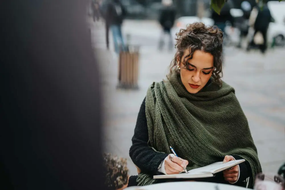 Woman journaling symptoms to understand changes in anxiety during menopause.