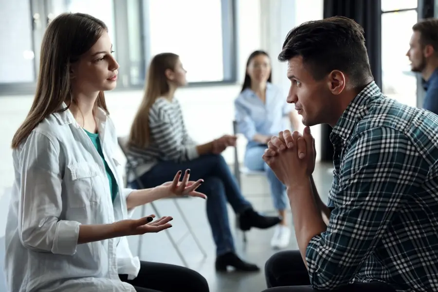 Partners in group exercise discussing php vs. iop treatment for mental health.