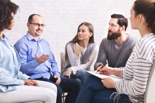 a group of people sit in a circle and learn about the benefits of 12 step program