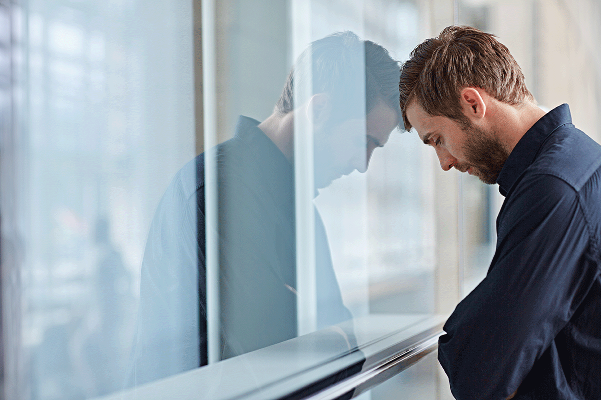 a person rests their head on a window to show a need for a depression residential treatment center