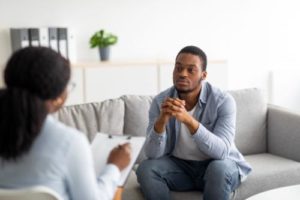 person on couch listening about baycare mental health treatment