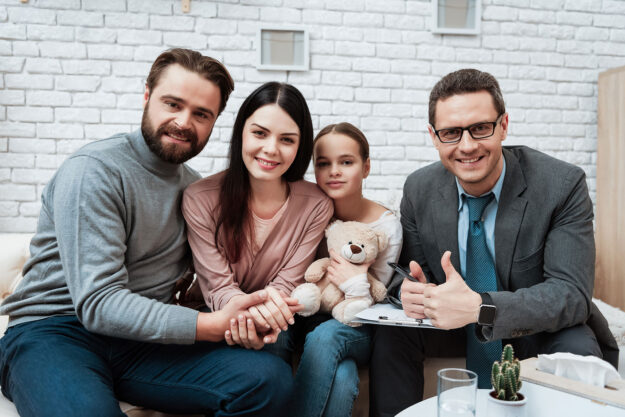 a family poses on a couch for a picture to show how family therapy for mental health can help