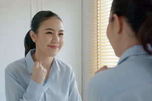 person smiling in mirror thanks to motivational enhancement therapy 