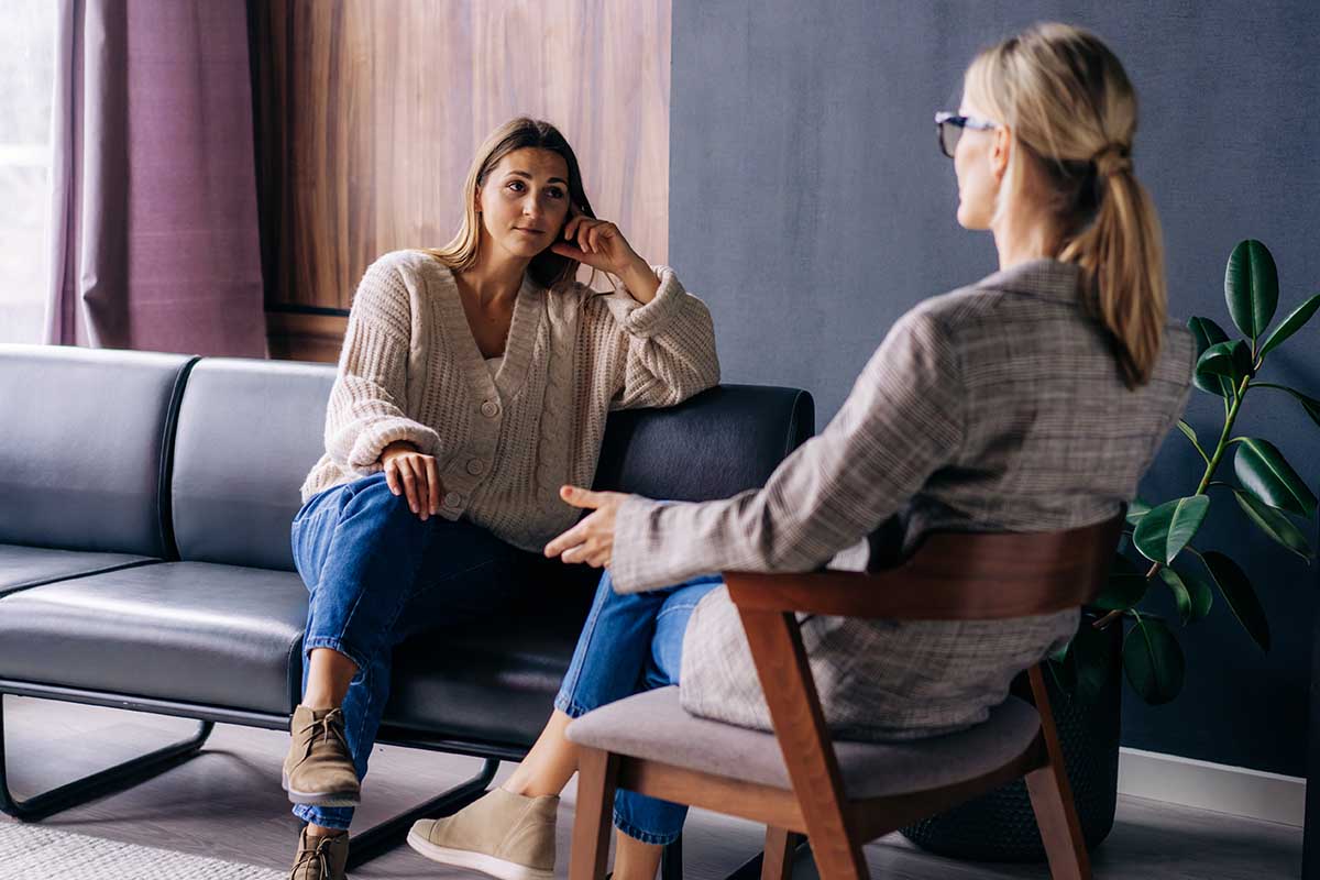 a patient learns questions to ask about depression treatment from a therapist while they sit across from each other in chairs