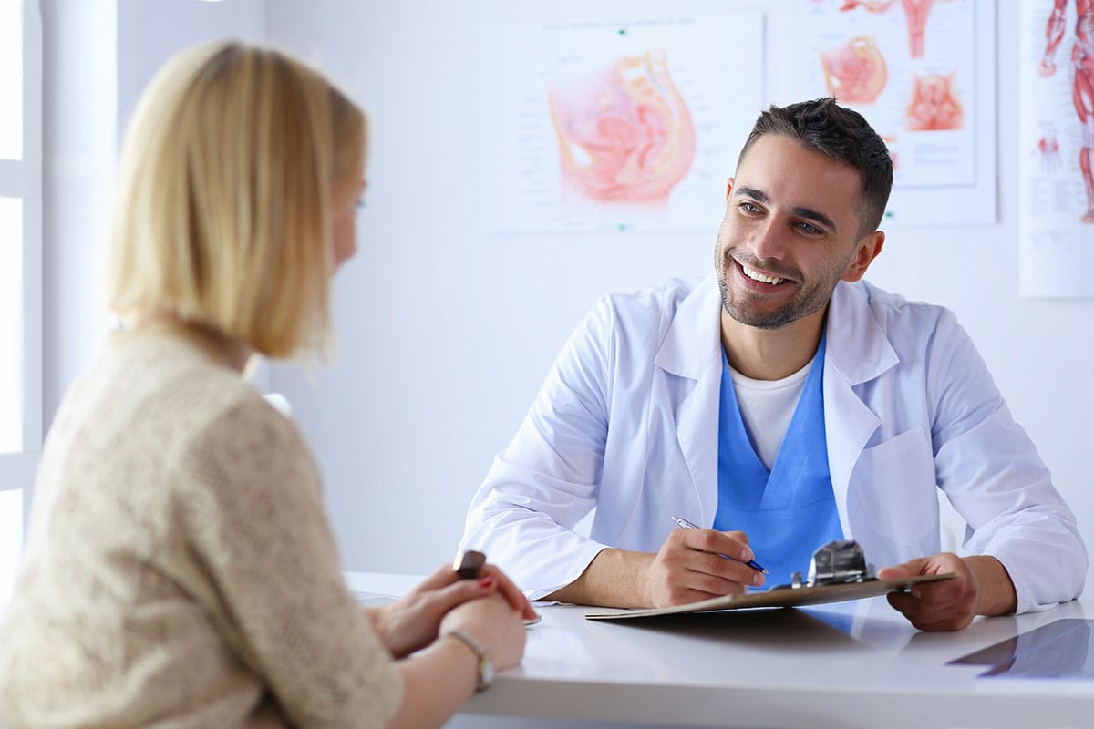 a woman talking to her doctor about the benefits of a medication management program