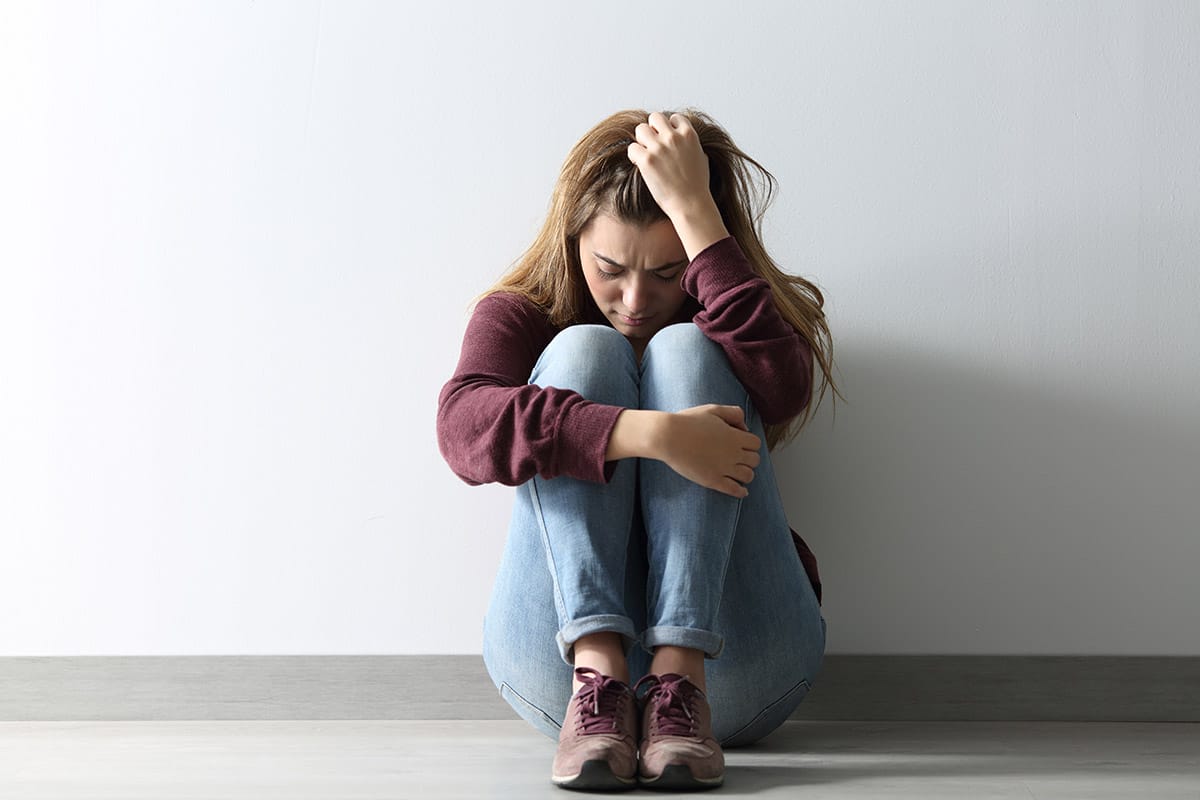 a woman sitting on the ground struggling with borderline personality disorder