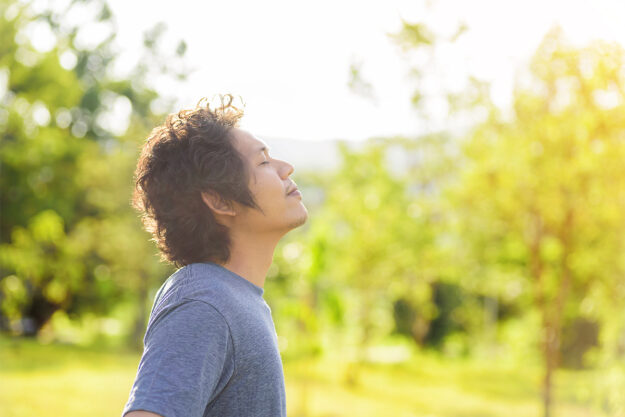 a man practices meditation outside as an anxiety therapy technique