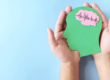 a person holds an artistic representation of the brain in a persons head