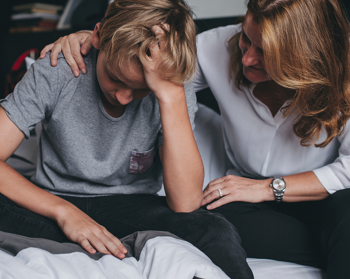 a younger person is comforted by an older person to show guardianship for schizophrenia