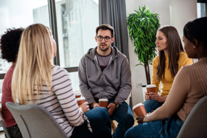 People sitting in a circle at a 12-step program for mental health