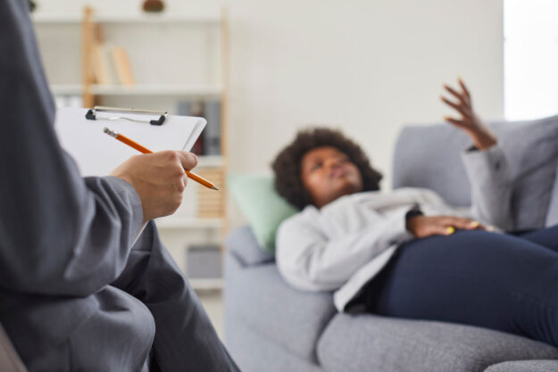someone lays on a couch and talks to a therapist about what is moral reconation therapy