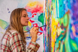 a woman paints in her art therapy program for mental health