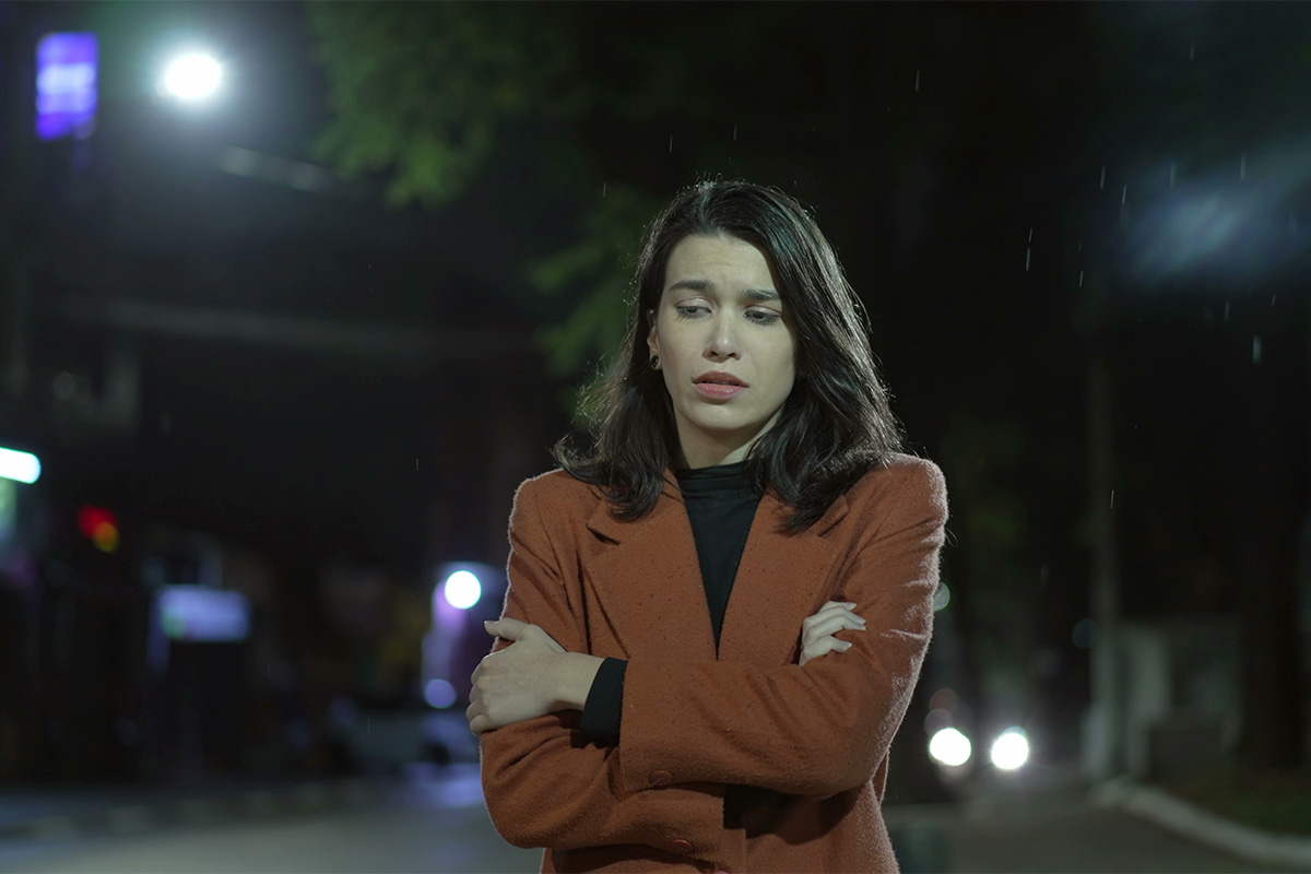 a woman struggles to calm her anxiety symptoms as she walks at night