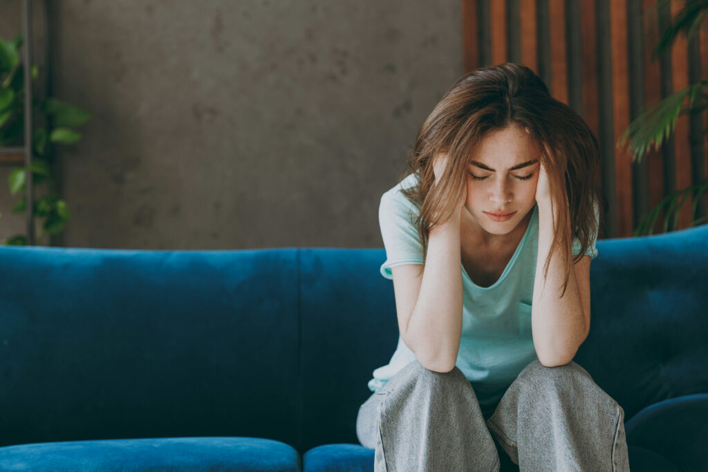 A survivor experiencing PTSD symptoms such as hypervigilance and intrusive memories after domestic violence.