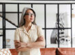 Middle-aged woman standing peacefully by a window, reflecting during the menopausal transition.