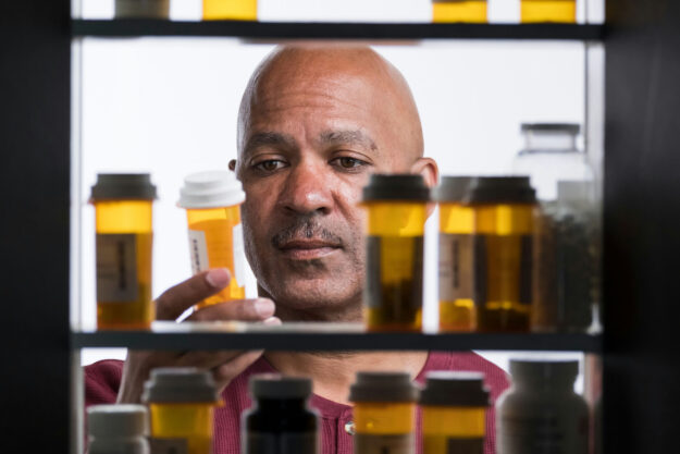 Adult reviewing a prescription muscle relaxer bottle while researching medication safety.