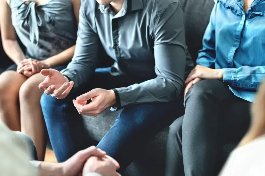 adult reflecting on childhood trauma during a family therapy session at a PTSD treatment center in Florida