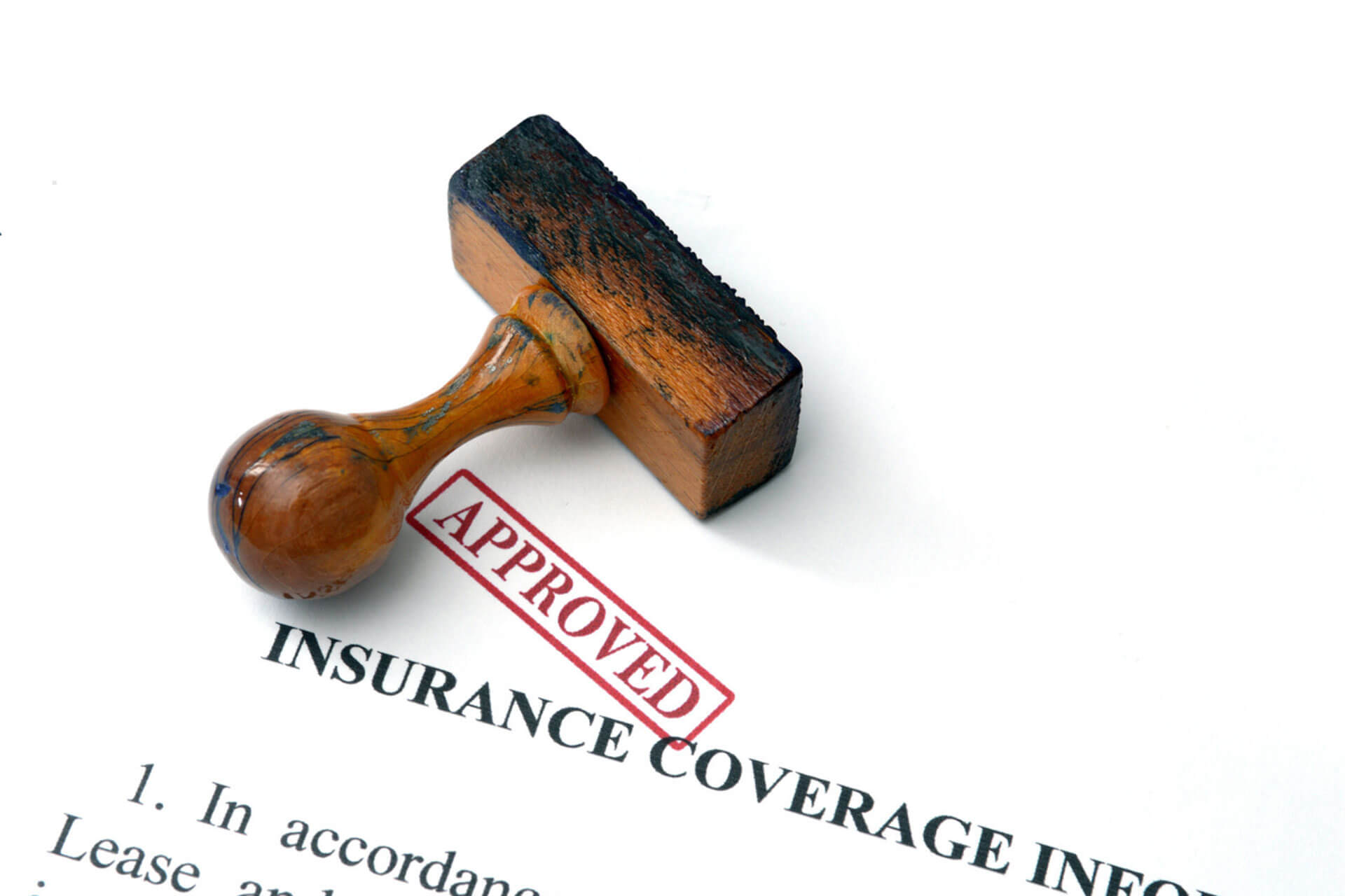 understanding-insurance-coverage-for-mental-health-treatment-in-florida A wooden stamp rests beside a red "Approved" mark on a document titled Insurance Coverage.